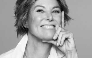 Smiling woman with short hair, thoughtful pose.