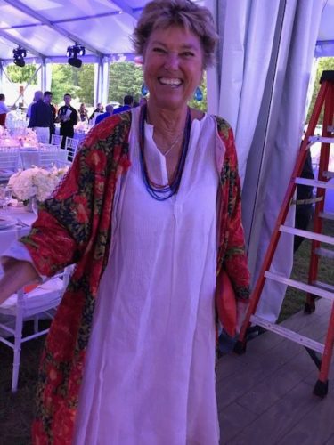 A woman in a colorful dress standing in a tent.