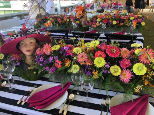 A table with a hat and flowers on it.