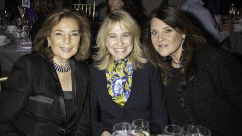 Three women posing for a photo at an event.