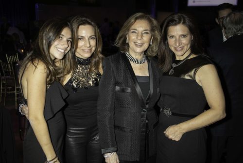 Three women posing for a photo at an event.