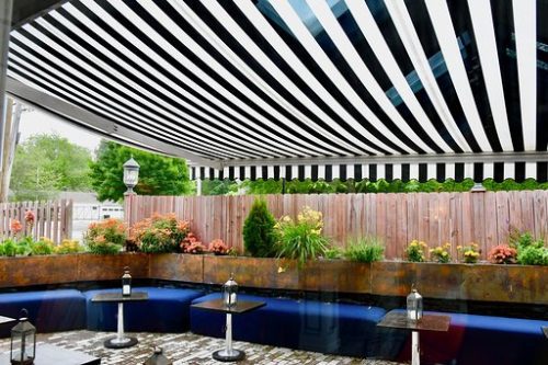 An outdoor patio with a striped awning.