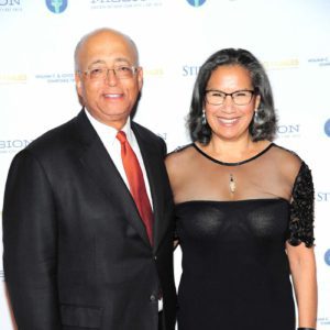 A man and woman standing next to each other on a red carpet.