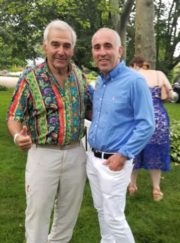 Two men standing next to each other at an outdoor event.