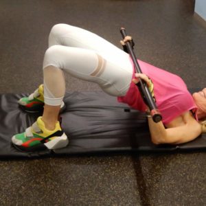 A woman doing a sit up on a mat.