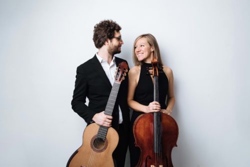 A man and woman are posing for a photo with a cello.