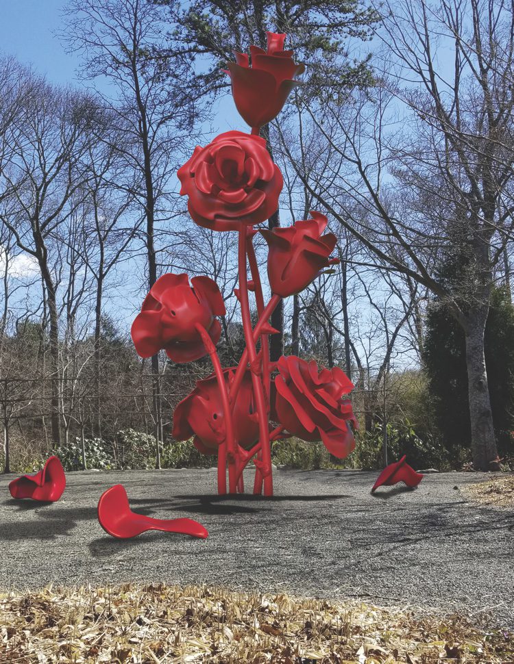 A sculpture of red roses in the middle of a park.