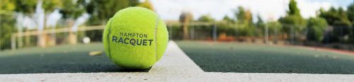 A tennis ball on a court with blurred background.
