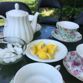 A table with tea cups and lemons on it.