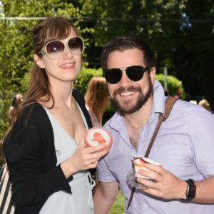 A man and woman posing for a photo at an outdoor event.