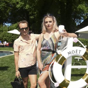 Two women standing next to a life ring at a pool.