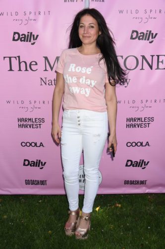 A woman wearing white jeans and a pink t shirt at the wild spirit event.