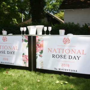 National rose day banners in front of a lawn.