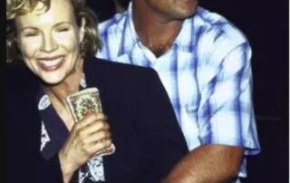 A man hugs a smiling woman from behind at a casual event.