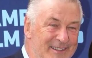 Here's an alt tag for the image: Alec Baldwin headshot, smiling.
