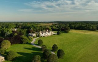 Aerial view of a large house on a green lawn.