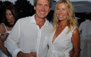 Smiling couple in white at a party.