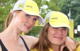 Two women wearing yellow "Hope" hats.