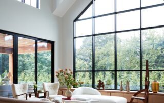 Modern living room with large windows and furniture.