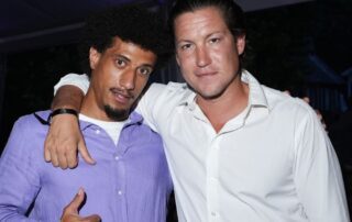 Two men in button-down shirts, smiling.