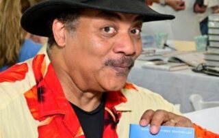 Neil deGrasse Tyson wearing a hat and shirt.