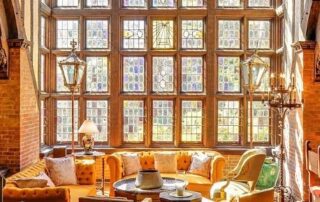 Sunlit room with stained glass windows and comfy seating.
