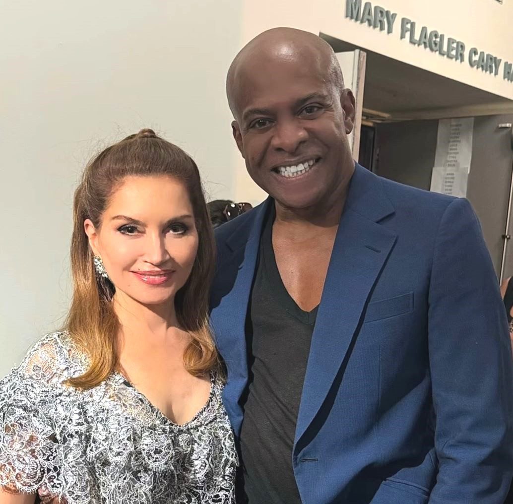 Young man with a slight smile against a gray background.