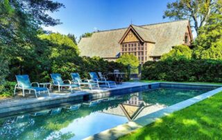 House with pool and lounge chairs.