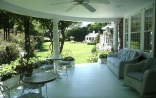 White porch overlooking green lawn.