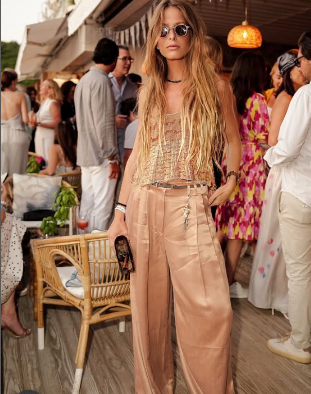 Stylish woman in satin pants and a textured top at a social event.