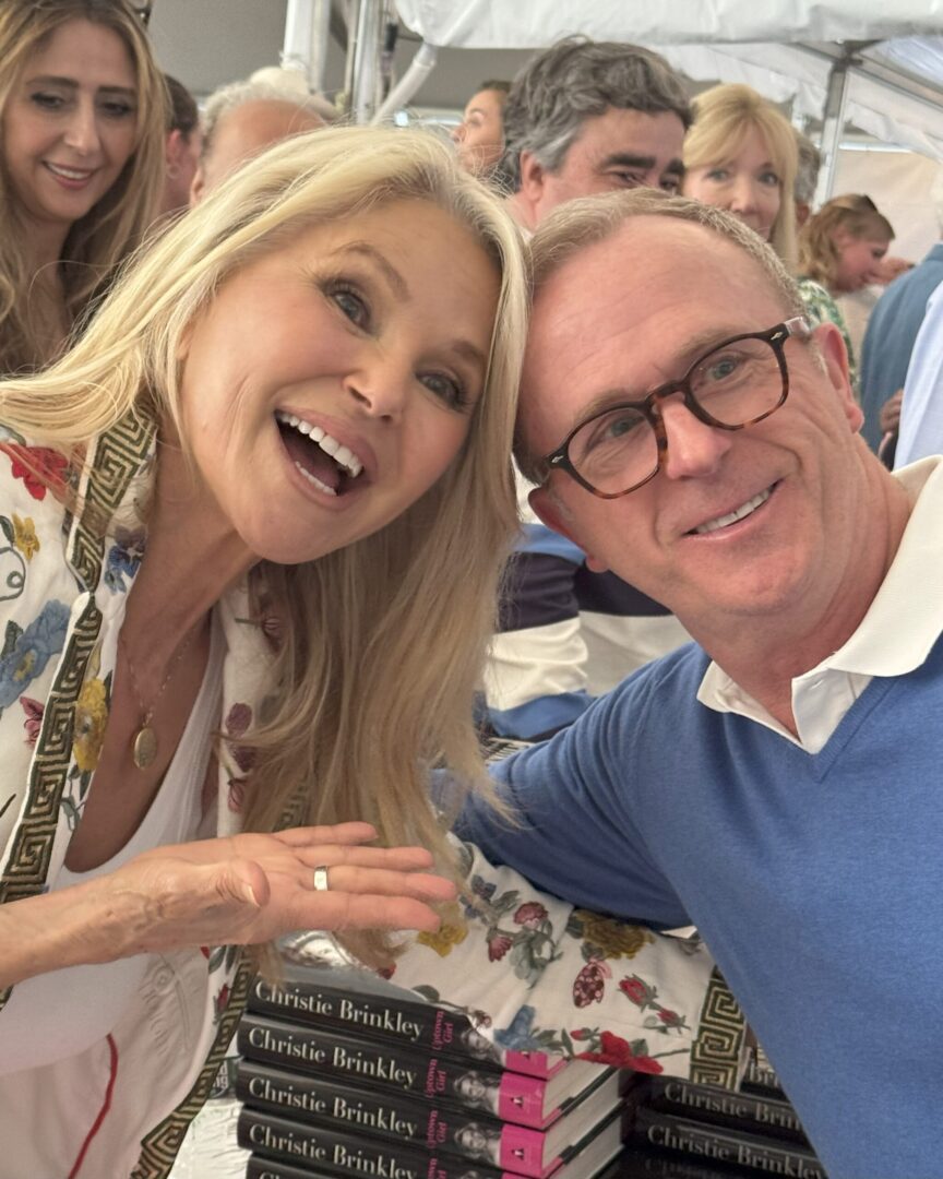 Two smiling people posing closely at an event.