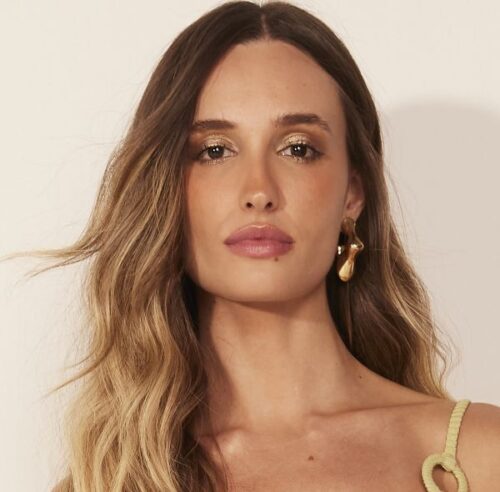 Close-up portrait of a woman with long hair and gold earrings.