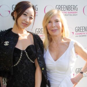 Two women posing at a Greenberg Cosmetic Surgery event.