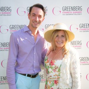 A man and woman smiling at a cosmetic surgery event.