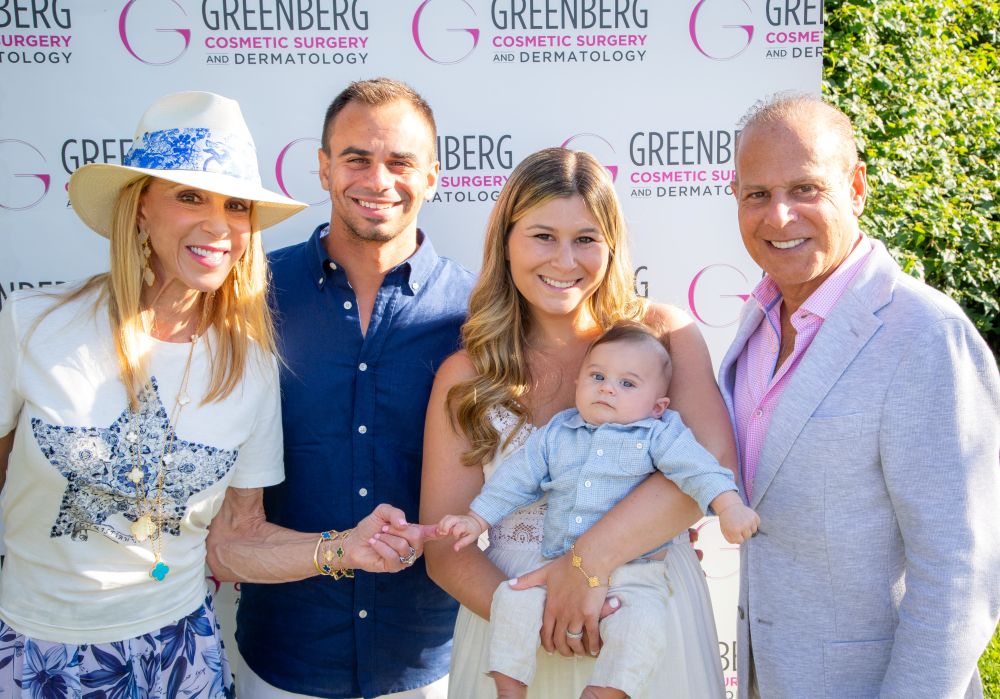 A happy family posing together at a Greenberg Cosmetic Surgery event.