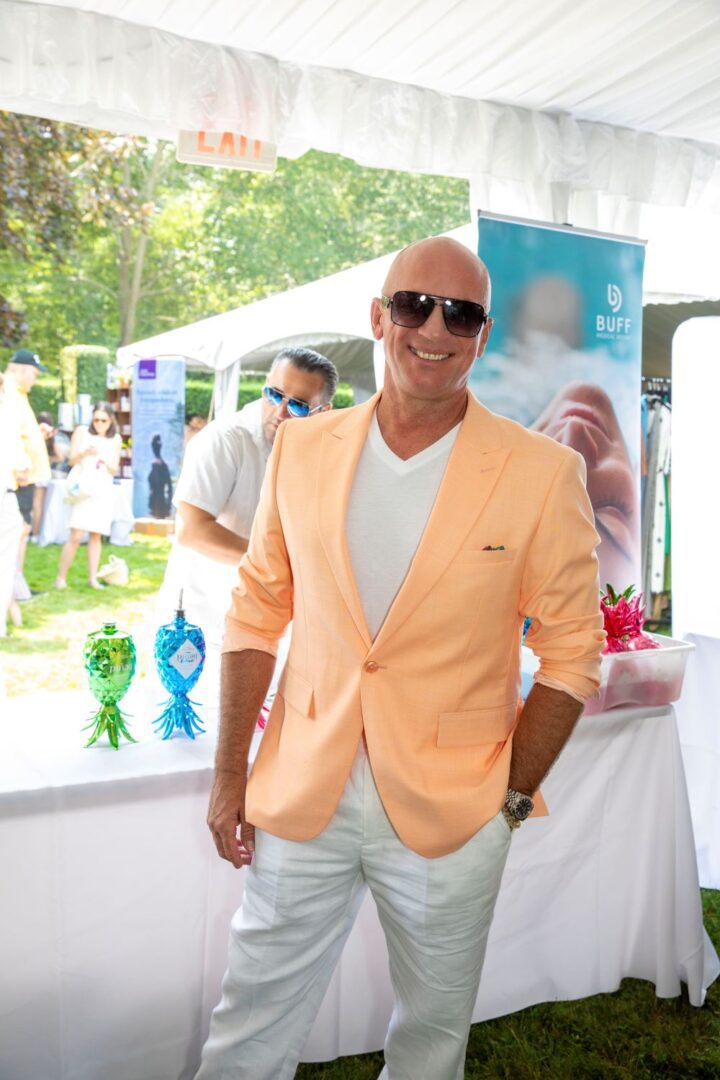 Young man with a slight smile against a gray background.