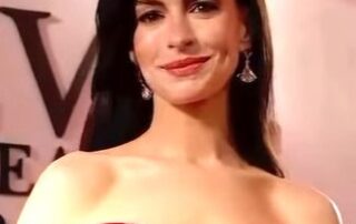 Woman in a red strapless gown smiling at an event.