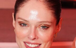 Close-up of a woman with slicked-back hair and a warm smile.