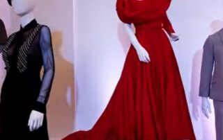 Elegant red evening gown with dramatic collar on a mannequin.